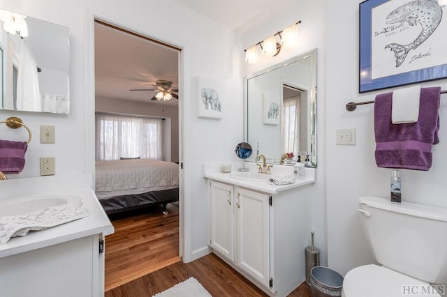 bathroom featuring ceiling fan, vanity, toilet, and hardwood / wood-style floors