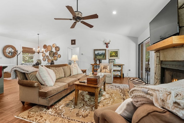86 Beech Ct, Sapphire, NC 28774 - living room with lofted ceiling, a chandelier, a ceiling fan, a warm lit fireplace, and wood finished floors