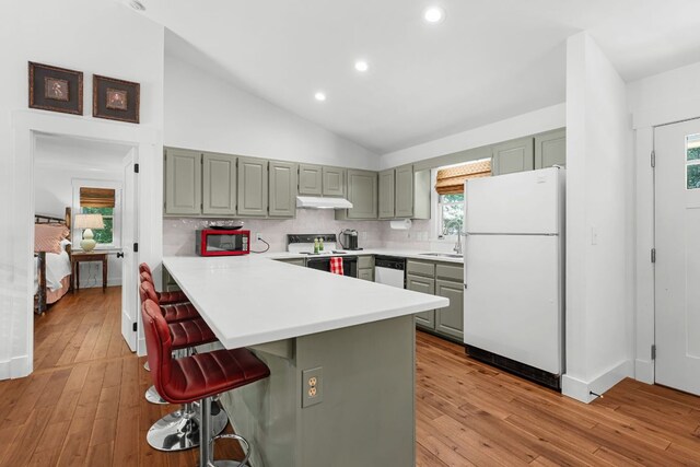 86 Beech Ct, Sapphire, NC 28774 - kitchen with white appliances, under cabinet range hood, light countertops, a breakfast bar, and backsplash