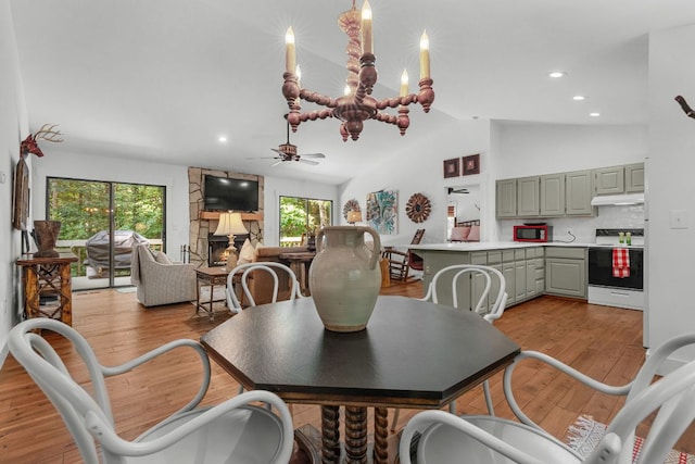 86 Beech Ct, Sapphire, NC 28774 - dining area with ceiling fan, healthy amount of natural light, a stone fireplace, lofted ceiling, and light wood-style flooring