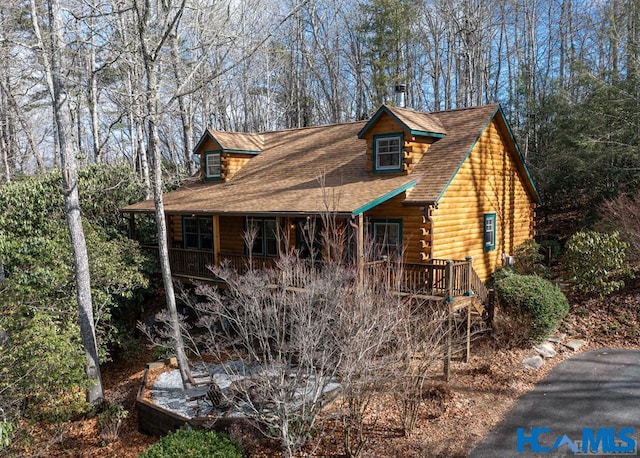 cabin with a porch and log siding