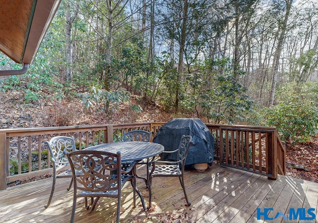 deck featuring outdoor dining space and grilling area