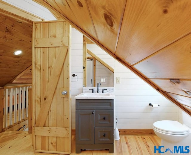 bathroom featuring wood ceiling, wooden walls, wood finished floors, and vanity