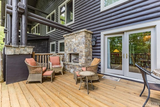 wooden terrace featuring a stone fireplace and french doors