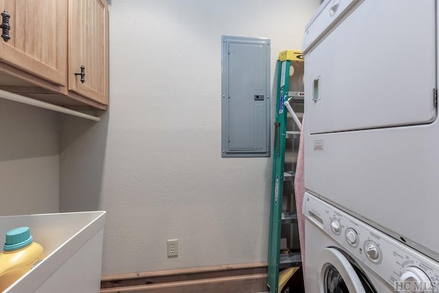 laundry room with stacked washing maching and dryer, electric panel, and cabinets