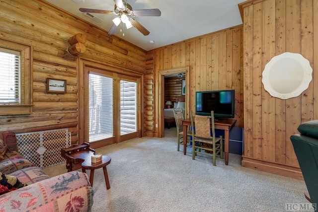 office space with light colored carpet, a wealth of natural light, log walls, and ceiling fan