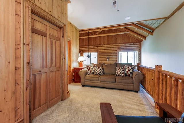 carpeted living room featuring lofted ceiling with beams, log walls, wood ceiling, and wood walls