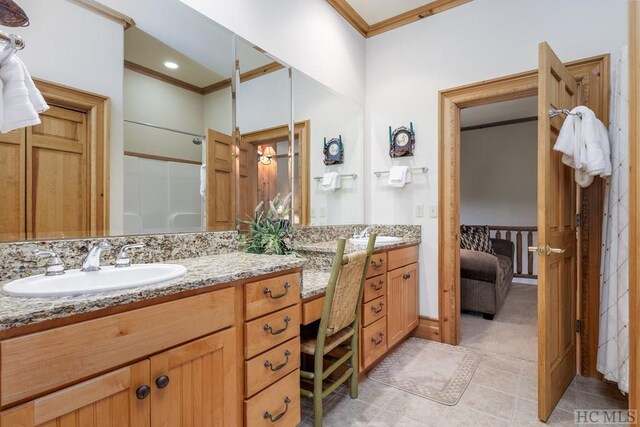 bathroom with ornamental molding, vanity, tile patterned flooring, and walk in shower