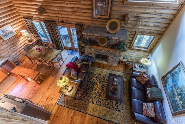 living room with a healthy amount of sunlight, hardwood / wood-style flooring, french doors, and a high ceiling