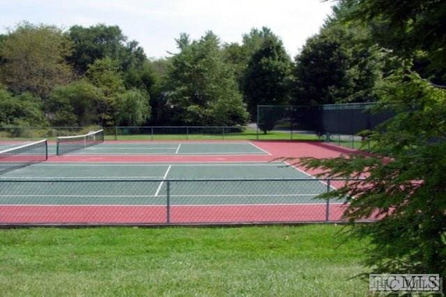 view of tennis court with a yard