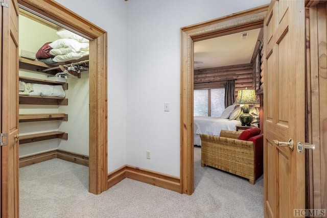 hallway with light carpet and log walls