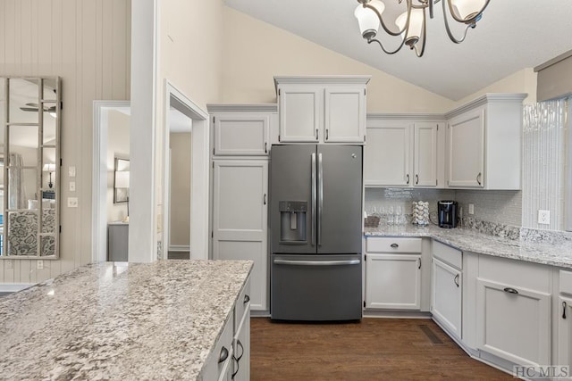 kitchen with tasteful backsplash, white cabinets, dark hardwood / wood-style flooring, light stone counters, and stainless steel refrigerator with ice dispenser