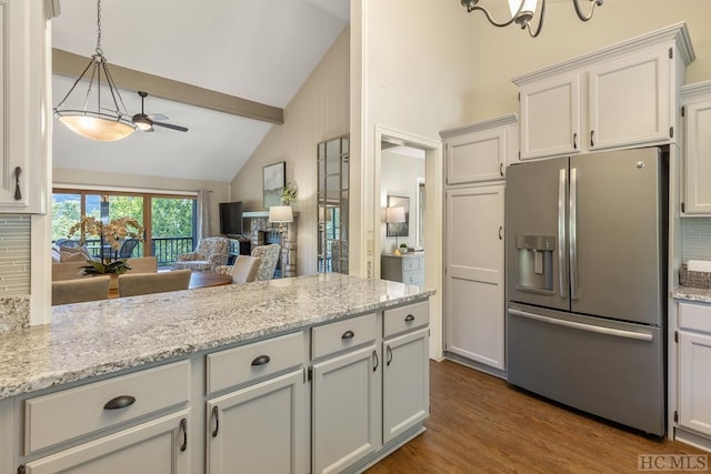 kitchen featuring decorative backsplash, white cabinets, and stainless steel refrigerator with ice dispenser