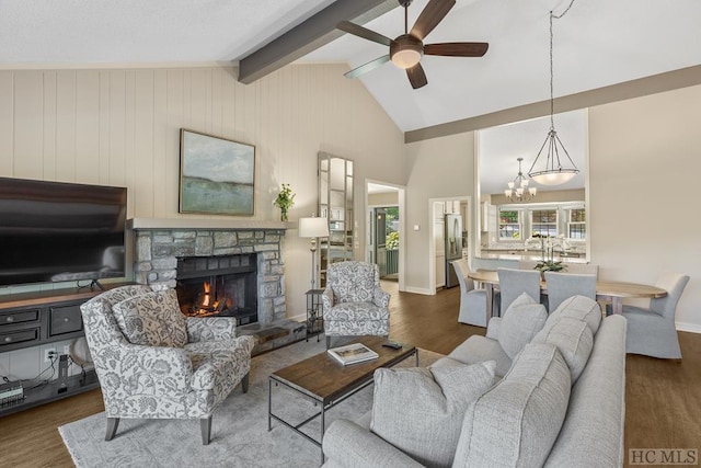 living room featuring ceiling fan with notable chandelier, a fireplace, lofted ceiling with beams, and dark hardwood / wood-style floors