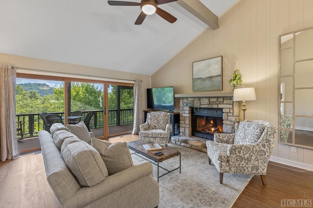 living room with hardwood / wood-style floors, beam ceiling, a wealth of natural light, and a fireplace