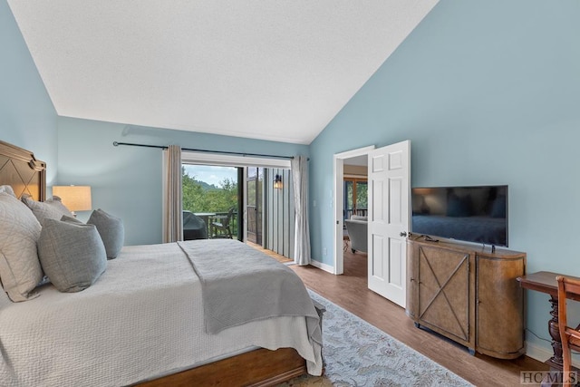 bedroom with wood-type flooring, vaulted ceiling, and access to exterior