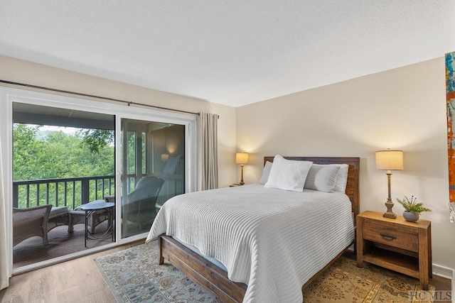 bedroom featuring wood-type flooring and access to exterior