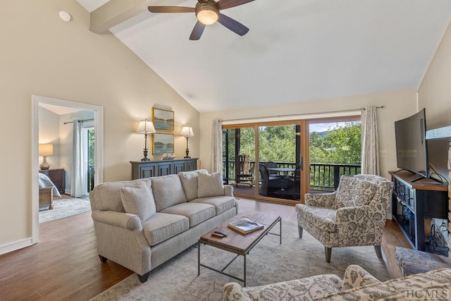 living room with high vaulted ceiling, plenty of natural light, beam ceiling, and light hardwood / wood-style floors