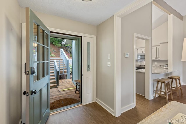 entryway featuring dark wood-type flooring and a textured ceiling