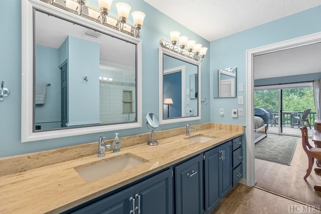 bathroom featuring vanity, wood-type flooring, and a textured ceiling