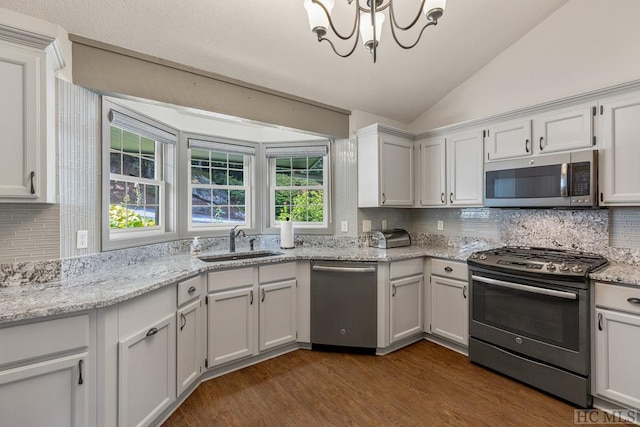 kitchen with dark hardwood / wood-style floors, white cabinetry, lofted ceiling, sink, and stainless steel appliances