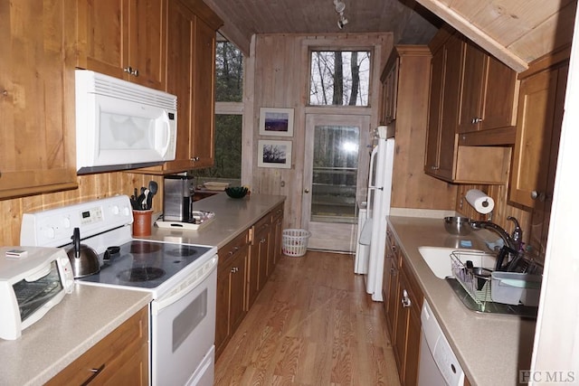 kitchen featuring sink, white appliances, wooden walls, light hardwood / wood-style floors, and wooden ceiling