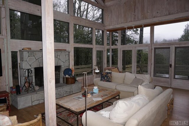 sunroom / solarium featuring a stone fireplace and a healthy amount of sunlight