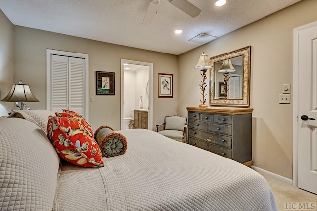 bedroom with connected bathroom, a textured ceiling, carpet floors, a closet, and ceiling fan