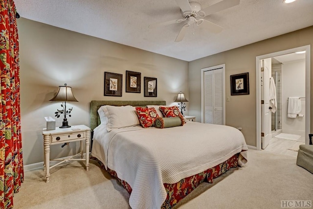 carpeted bedroom with ensuite bath, a textured ceiling, ceiling fan, and a closet