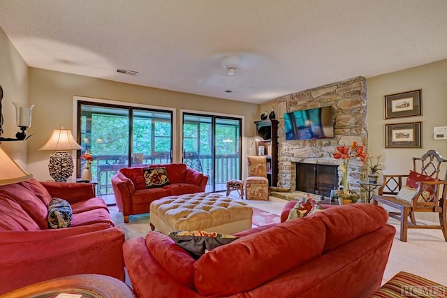 living room featuring a stone fireplace and a textured ceiling