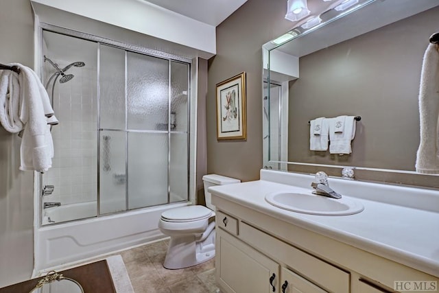 full bathroom with vanity, bath / shower combo with glass door, and toilet