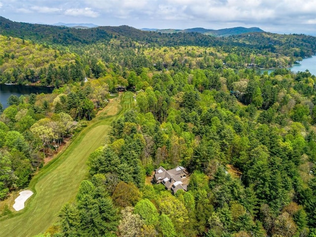 aerial view with view of golf course, a wooded view, and a water and mountain view