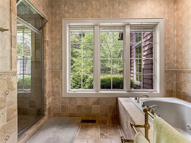 full bathroom with a tile shower, a whirlpool tub, visible vents, and plenty of natural light