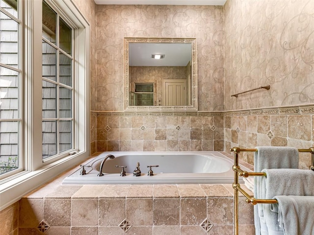 full bath featuring a garden tub and tile walls