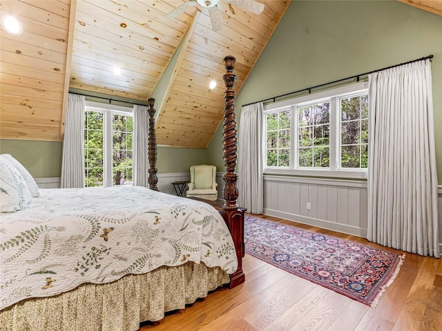 bedroom with multiple windows, wood-type flooring, and lofted ceiling