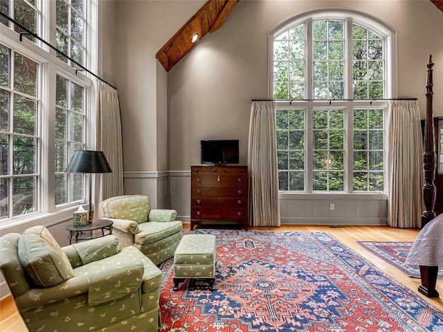 living area with wainscoting and wood finished floors