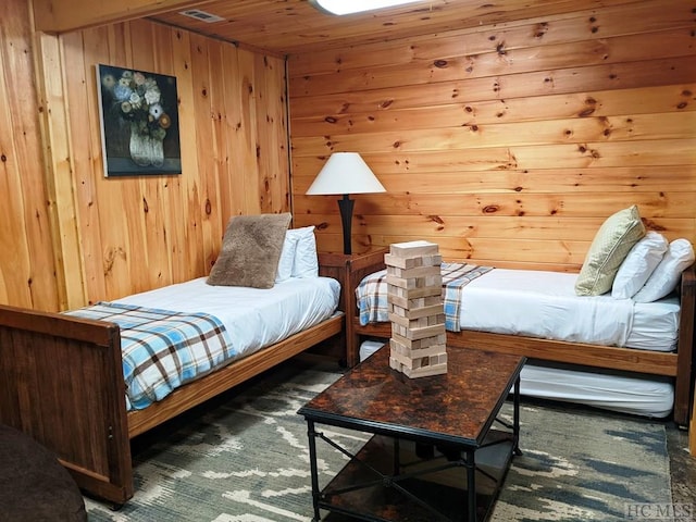 bedroom with wooden walls and dark colored carpet