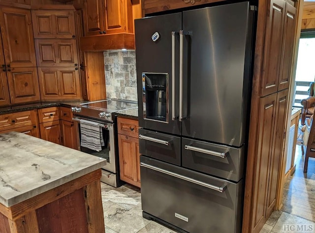 kitchen with tasteful backsplash, appliances with stainless steel finishes, and dark stone countertops