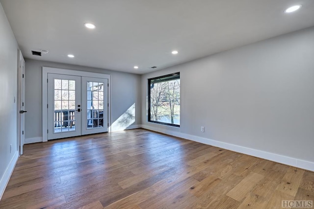 spare room featuring hardwood / wood-style flooring and french doors