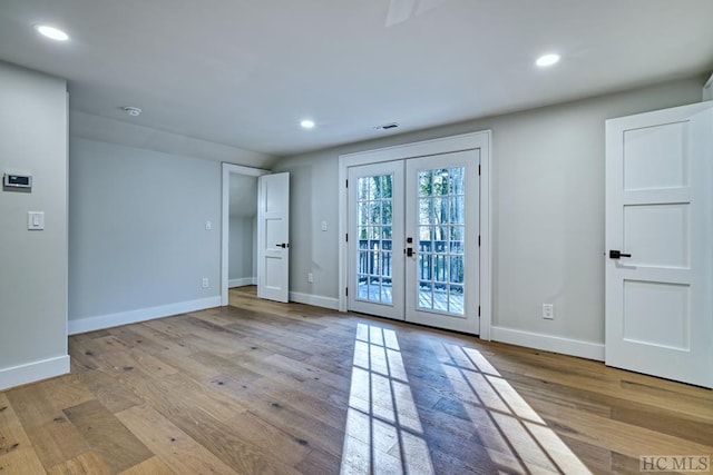 unfurnished room with french doors and light wood-type flooring