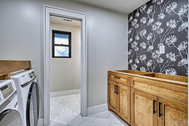 washroom featuring cabinets, light tile patterned floors, and independent washer and dryer