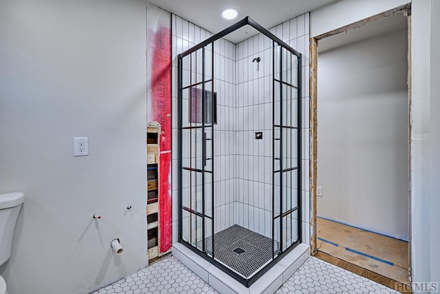 bathroom featuring an enclosed shower and toilet