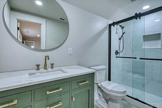 bathroom featuring vanity, toilet, and a shower with shower door