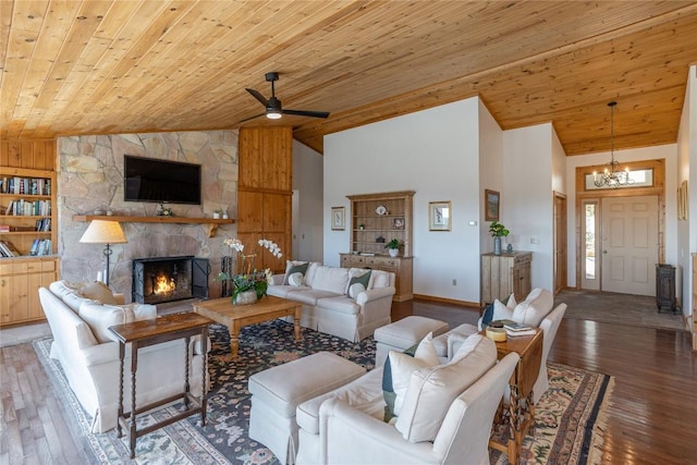 living room featuring ceiling fan with notable chandelier, wooden ceiling, a fireplace, and wood-type flooring