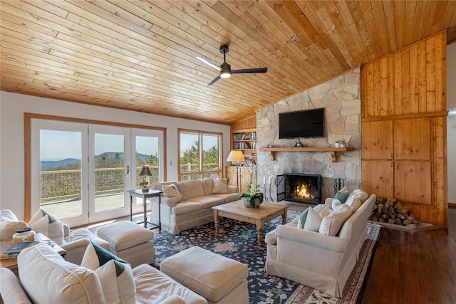 living room featuring wood finished floors, a ceiling fan, a stone fireplace, wood ceiling, and french doors