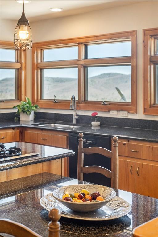 kitchen with a sink, decorative light fixtures, black appliances, and brown cabinetry