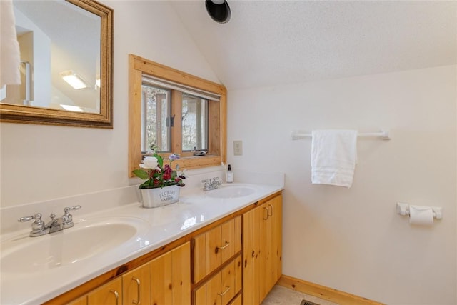 full bathroom featuring double vanity, baseboards, lofted ceiling, and a sink