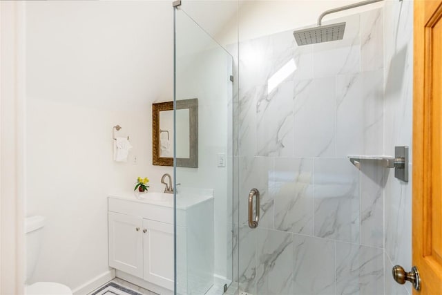 full bath featuring vanity, toilet, and a marble finish shower