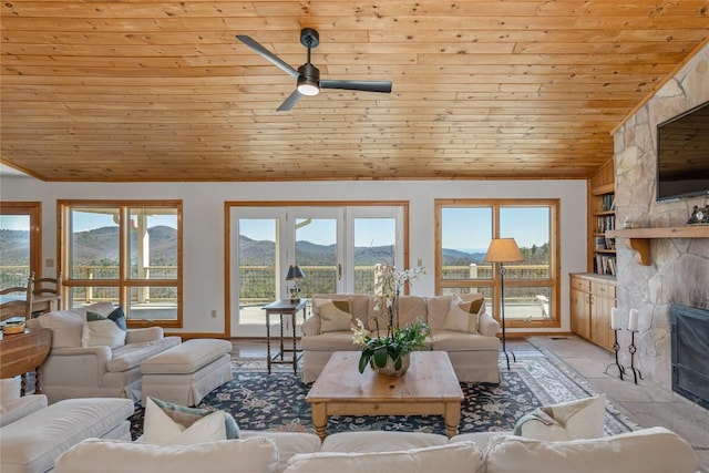 living area with ornamental molding, a ceiling fan, wooden ceiling, a fireplace, and vaulted ceiling