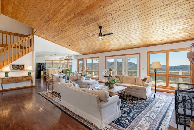 living room featuring ceiling fan with notable chandelier, stairs, a mountain view, wood ceiling, and dark wood-style flooring